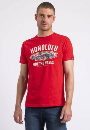 T-shirt en coton rouge avec un design graphique comprenant le texte "HONOLULU", une illustration de planche de surf florale et des manches courtes. Étiquette bleue sur le côté.