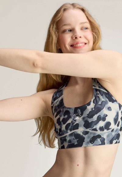Sports bra in a black and gray leopard print, featuring a scoop neckline, wide straps, and contrasting stitching details. Soft, stretchy fabric.