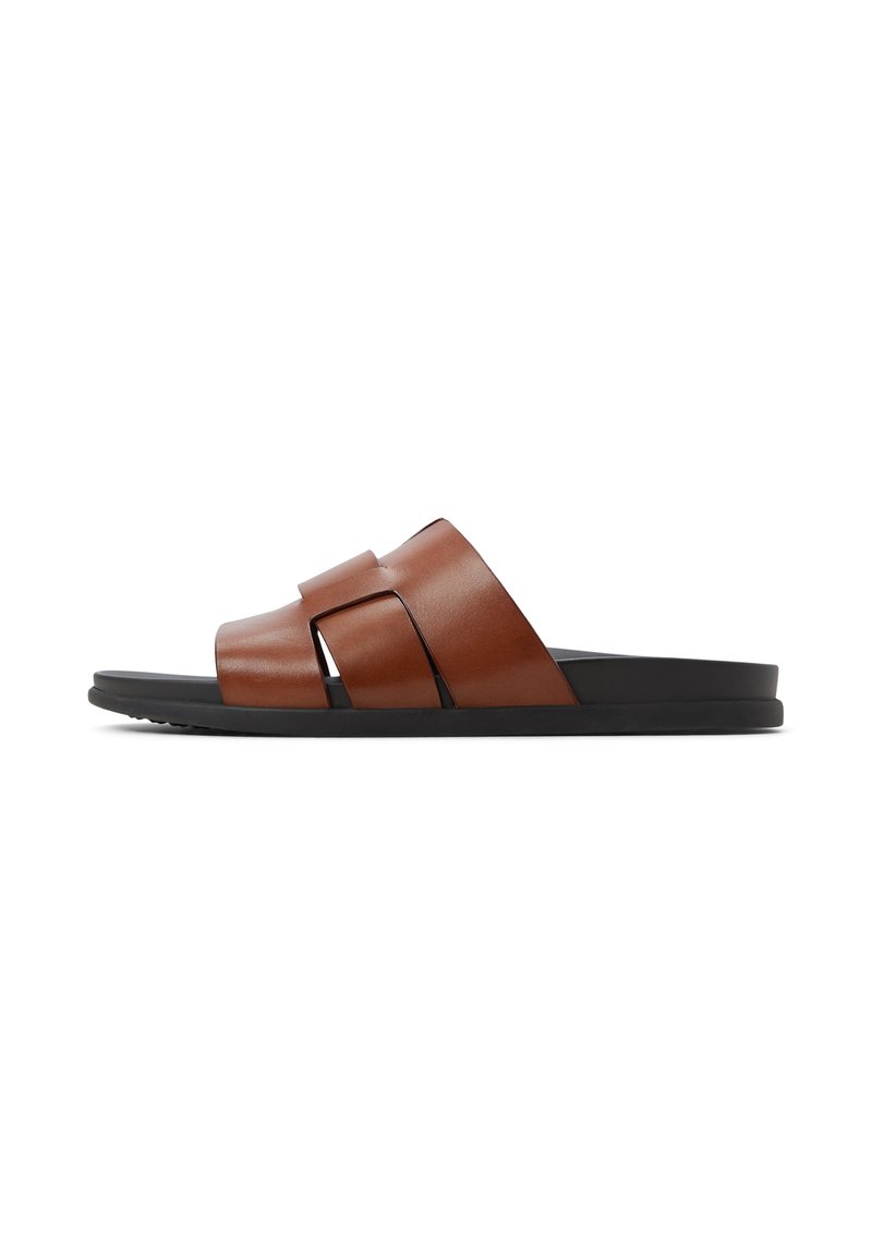 Brune lædersandal med to brede stropper. Sort gummisål. Slank silhuet med åben tå og minimalistisk design.