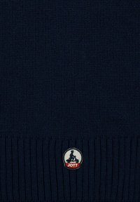 Gorro de lana navy con textura acanalada, que presenta un logo bordado en blanco y rojo en el borde inferior.
