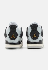 Black and light blue sneakers with a padded collar, rubber outsole, and gold Jordan logo on the heel, featuring a mesh panel design.