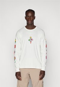 Wit T-shirt met lange mouwen van katoen, voorzien van kleurrijke graphics en patronen op zowel de mouwen als de borst, met een ronde halslijn.