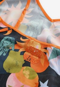 Többszínű ujjatlan ruhadarab narancssárga szegéllyel, kör alakú mintákkal, virágmotívumokkal és hímzett pillangó díszítéssel.