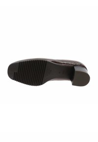 Suela de zapato marrón oscuro con textura en la parte delantera para agarre y tacón bajo, vista desde abajo sobre un fondo blanco.