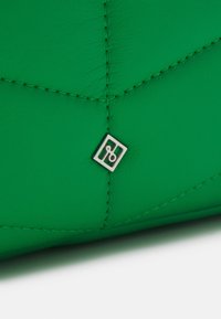 Green leather handbag with quilted texture. Features a silver square logo accent and contrasting stitching. Compact and structured design.