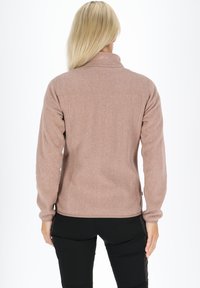 Brun fleecejakke med høj krave, der har en blød tekstur og lynlås, set fra ryggen med lange ærmer og en tætsiddende pasform.