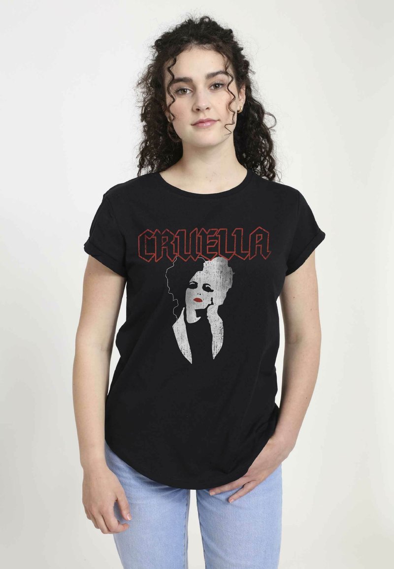 Sort bomulds T-shirt med et grafisk tryk af et kvindeligt ansigt i grå og rød med teksten "CRUELLA" i fede, stiliserede bogstaver.