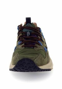 Sneakers en suede vert et textile avec des accents de lacets bleus et violets, semelle en caoutchouc et languette matelassée pour le confort. Vue de face présentant les détails du design.