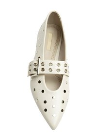 Zapato blanco de punta afilada con orificios recortados, una correa ancha con accesorios metálicos y un acabado liso y brillante.