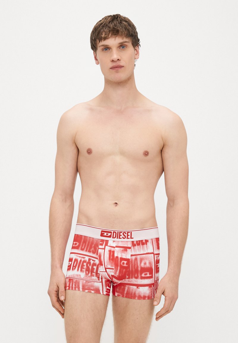 Boxer rossi con una fascia in vita bianca recante il logo "DIESEL". Il materiale è liscio, con un motivo ripetuto in diverse tonalità di rosso.