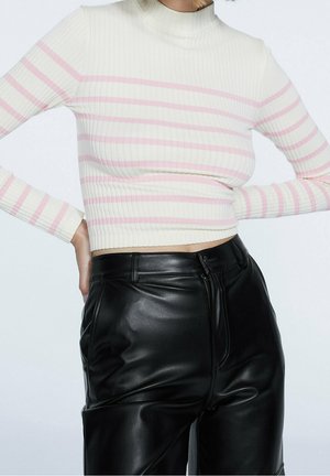 Maglietta a maniche lunghe, aderente con colletto a polo in tessuto a coste, color crema con righe orizzontali rosa; abbinata a pantaloni in finta pelle nera.