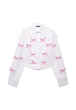 White cropped shirt with long sleeves, featuring multiple pink ribbon accents in a crisscross pattern along the front and sleeves.