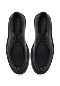 Scarpe di pelle nera con un design arrotondato, dettagli cuciti e una finitura liscia. La parte superiore presenta un dettaglio con lacci e una forma sagomata.