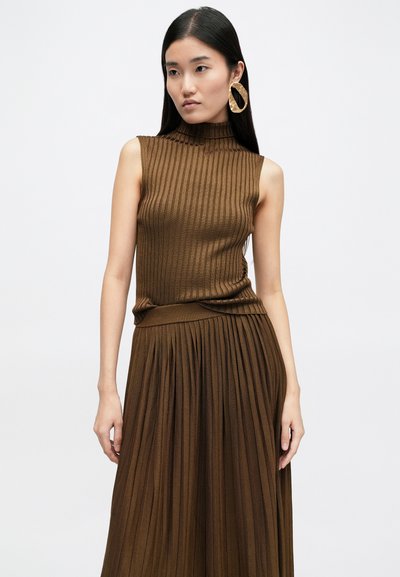 Καφέ ριγωτό αμάνικο τοπ με ψηλό λαιμό, συνδυασμένο με μια ταιριαστή ανάλαφρη φούστα με πιέτες. Διαθέτει μαλακή υφή και εφαρμοστή σιλουέτα.