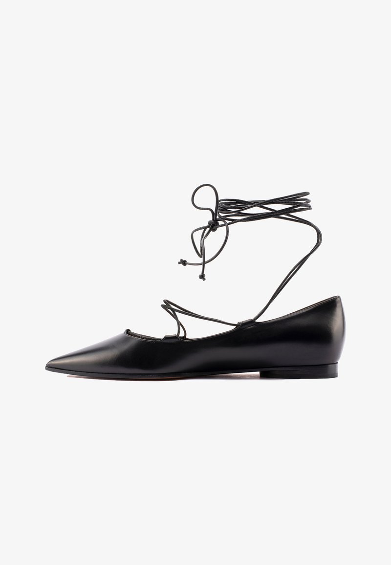 Schwarze Lederflats mit spitzem Zeh, ausgeschnittenen Seiten und umwickelbaren Schnürsenkeln. Glatte Textur und minimalistisches Design mit niedrigem Absatz.