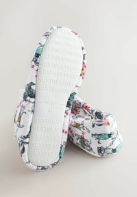 Mustrilised sussid valge kangaseina ja värvikate loomade illustratsioonidega. Tekstuuriga kummist tald, millel on reljeefne bränding.