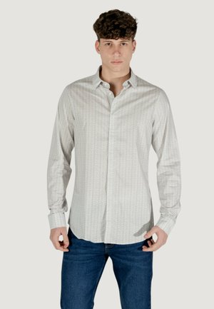 Camicia a maniche lunghe di colore chiaro con un motivo geometrico, realizzata in tessuto morbido, dotata di colletto button-down e polsini abbottonati.