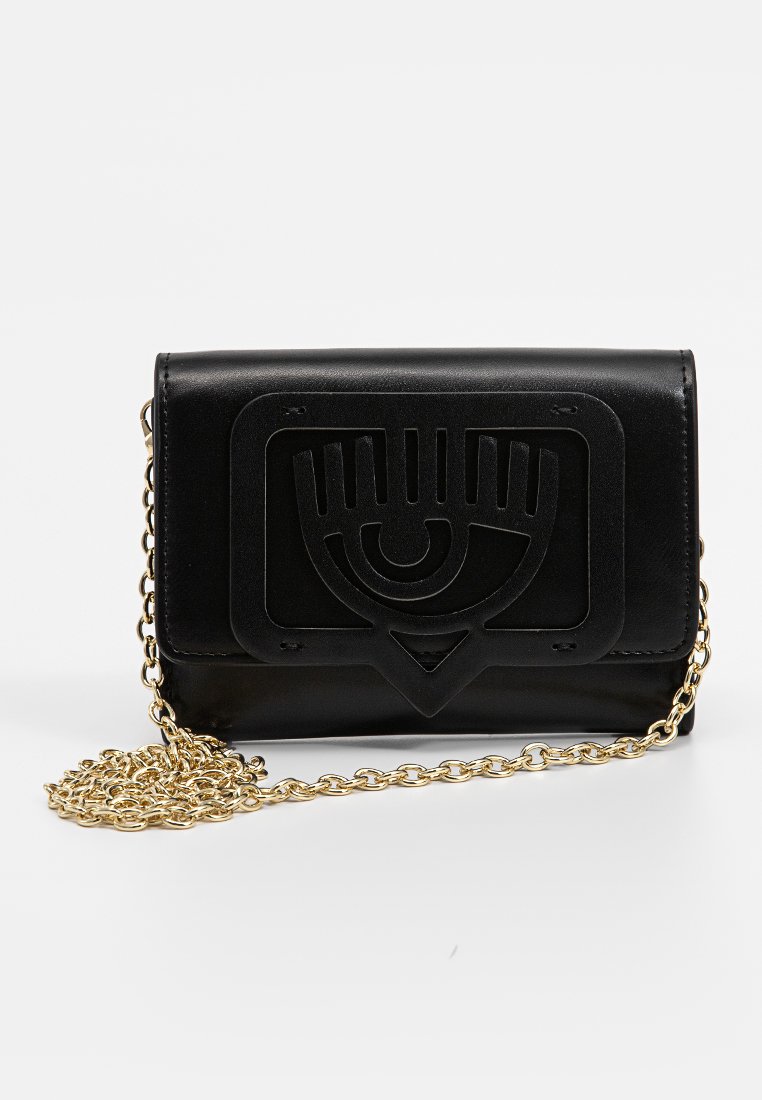 Clutch de cuero negro con diseño de ojo en relieve en la parte frontal y cadena dorada, exhibido sobre un fondo neutro.