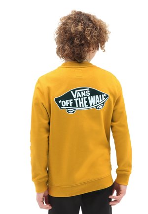 Sweat-shirt jaune à col rond ; présente un grand logo noir et blanc « Vans Off the Wall » au dos et des poignets côtelés.