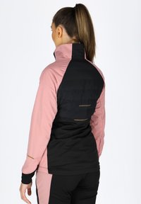 Schwarze und rosa Jacke mit hohem Kragen, gepolstertem Rücken und glattem Stoff mit kontrastierenden Akzenten. Logo auf der Rückseite sichtbar.