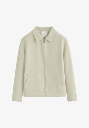 Veste beige clair zippée avec col et deux poches avant, manches longues et design épuré et minimaliste.