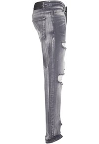 Jeans in denim grigio sbiadito con dettagli strappati, caratterizzati da strappi alle ginocchia e una vestibilità slim. Include una vita scura e accenti cuciti.