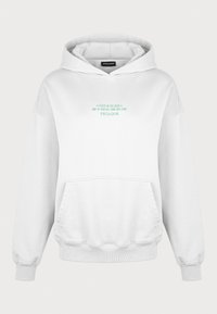 Bílá bavlněná mikina s kapucí s klokankou. Tisk textu v zelené barvě na hrudi říká "Soustřeď se na to dobré" spolu s "Pegador."