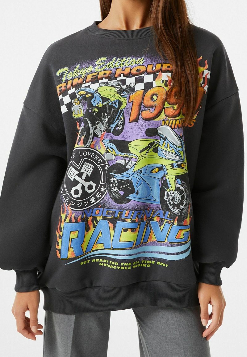Sudadera negra con impresiones gráficas vibrantes de motocicletas, llamas y texto. Puños y dobladillo acanalados, corte oversize, material de mezcla de algodón.