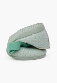 Zapatilla de tela verde con exterior de malla texturizada, plantilla acolchada y cinta elástica para un ajuste seguro, con forma redondeada.