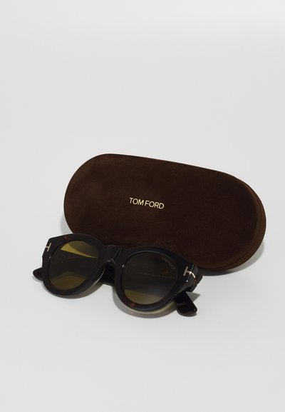 Ochelari de soare Tom Ford cu ramă rotundă neagră și din scoică țestoasă, lentile maro și detalii cu logo auriu. Include un toc din suede maro.