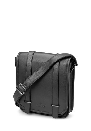 Sort lær crossbody-veske med justerbar rem, frontklaff og to vertikale stropper med metallspenner.