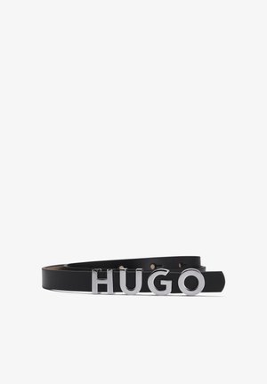 Črn usnjen pas z velikimi srebrnimi kovinskimi črkami, ki tvorijo napis "HUGO." Gladka tekstura s sodobnim dizajnom in enojnim zaponko.