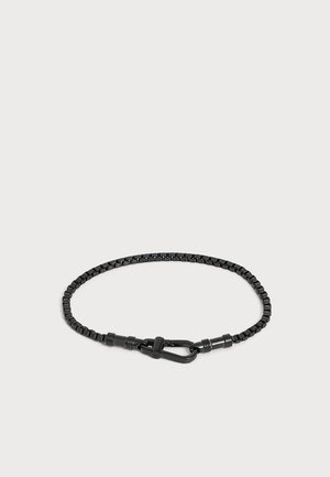 Bracelet chaîne en métal noir avec fermoir mousqueton sécurisé sur fond clair uni.