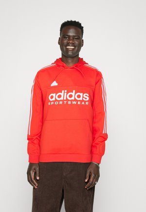 Rode Adidas hoodie met een kangoeroezak, wit logo en drie witte strepen op de mouwen. Beschikt over een trekkoordkap en ribgebreide manchetten.