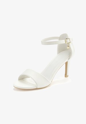 White leather heeled sandal featuring an ankle strap with a gold buckle, open toe design, and a smooth, glossy texture.