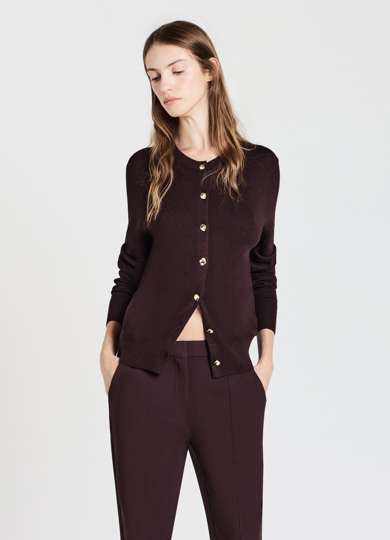 Cardigan bordeaux con scollatura rotonda, maniche lunghe e bottoni dorati sul davanti, realizzato in tessuto morbido e strutturato.