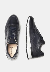 Zapatillas de cuero marino con una textura suave, punta redonda, diseño con cordones y suela de goma blanca con un patrón segmentado.