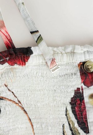 Weißer Stoff mit geraffter Textur, verstellbarem Schulterriemen, floralem rot-schwarzem Druck und beigen Knöpfen an der Seite.