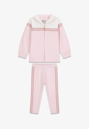 Set composto da felpa con cappuccio e leggings rosa chiaro in tessuto morbido. La felpa presenta una sezione superiore bianca e una cerniera, mentre i leggings hanno strisce con il logo.
