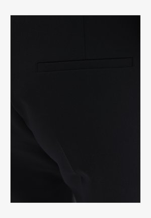 Pantalones negros de corte ajustado con una textura de tejido suave, que cuentan con un bolsillo trasero discreto y un diseño elegante. Silueta minimalista y ajustada.