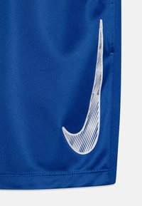 Sinised spordilühikesed püksid, mis on valmistatud tekstuuriga kangast ja millel on külgedel silmapaistev valge Nike swooshi logo, sile viimistlus ja puhtad õmblused.