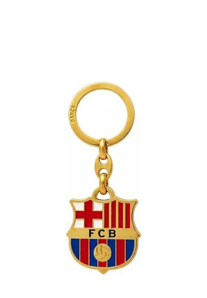 Złoty brelok do kluczy z zawieszonym emblematem herbu FC Barcelona, z czerwonymi, niebieskimi i białymi paskami oraz literami FCB w kolorze czarnym.