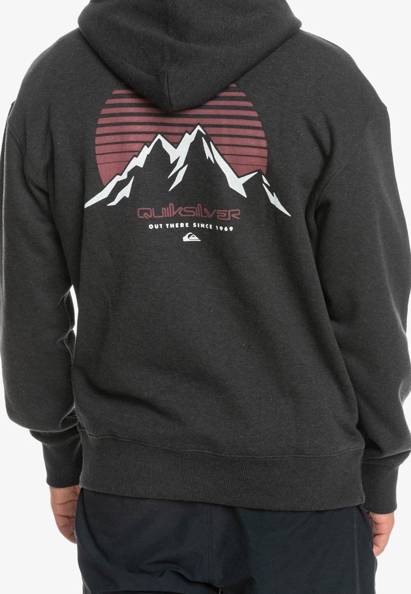 Felpa nera con cappuccio, caratterizzata da una grafica di montagne e un tramonto, con righe e il logo "Quiksilver" in rosso e bianco.