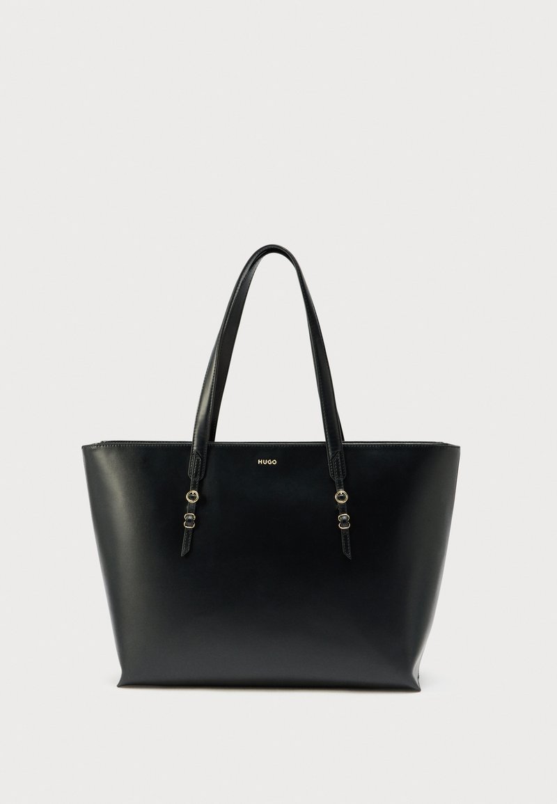 Sac fourre-tout noir en cuir lisse, doté de deux poignées, d'accents en métal doré et d'un design minimaliste avec logo sur le devant.
