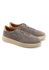 Szare zamszowe sneakersy z beżową gumową podeszwą, z perforowanym wzorem, płaskimi sznurowadłami i brązowym wnętrzem. Niski profil i zaokrąglony czubek.