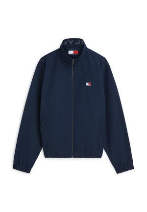 Marineblaue Jacke mit Reißverschluss und elastischen Bündchen, mit einem kleinen Tommy Jeans-Logo auf der Brust und einer Markenkennzeichnung im Kragen.