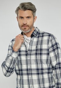 Koszula w kratę z flaneli w kolorze kremowym, granatowym i szarym. Zapięcie na guziki, z kołnierzykiem, featuring małe logo na piersi i guziki z detalami.