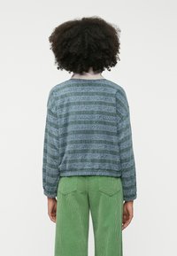 Μπλουζάκι με μακριά μανίκια σε μπλε-πράσ�ινο χρώμα με οριζόντιες ρίγες και λουλουδάτα σχέδια; στρογγυλή λαιμόκοψη, χαλαρή εφαρμογή, φουσκωτά μανίκια, σε συνδυασμό με πράσινα παντελόνια από κορντόροι.