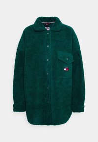 Grön fleecejacka med knappstängning, krage och en bröstficka. Har en liten logotypapplikation på fickan.