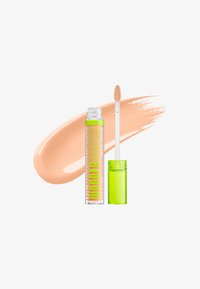 Tube transparent de correcteur NYX Wonderstick avec bouchon vert citron et applicateur, présenté à côté d'un échantillon de correcteur couleur pêche.